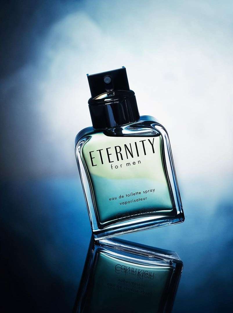 Eternity for Men cologne by Calvin Klein. The square glass bottle with black spray nozzle is displayed on a reflective surface.