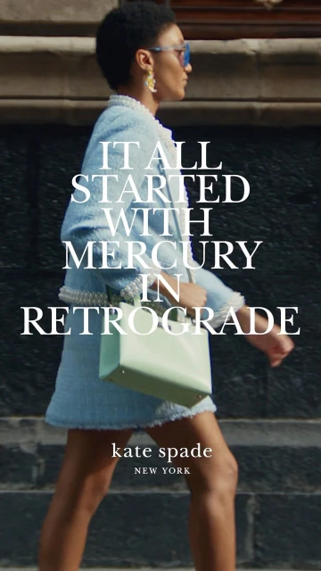 Woman in tweed skirt suit walks on city street carrying light green purse, advertising Kate Spade New York with large text overlay.