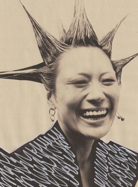 Close-up shot of smiling Asian woman with spiky hairstyle and digital squiggle effect on blazer, set against a neutral background.