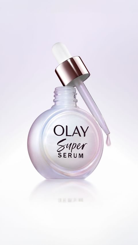 Olay Super Serum bottle with dropper set against a soft gradient backdrop, showcasing beauty and skincare product photography.