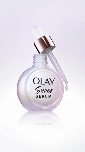 Olay Super Serum bottle with dropper set against a soft gradient backdrop, showcasing beauty and skincare product photography.