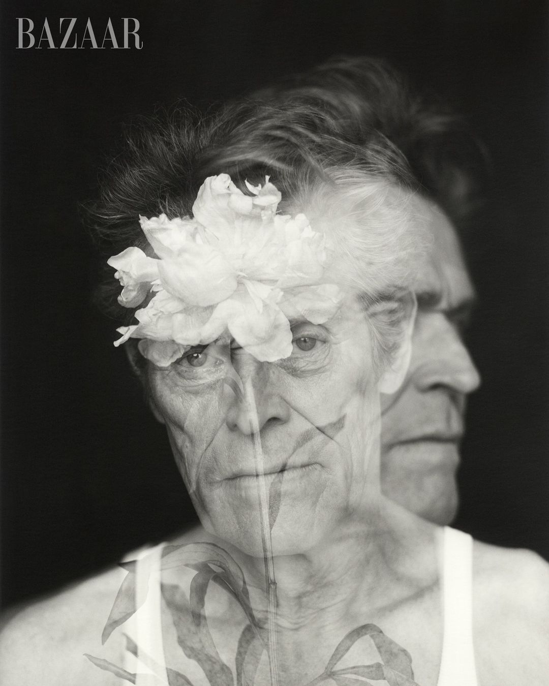 Monochrome portrait of older man with flower overlay and Bazaar logo, artistic style, and a sense of depth from dual-profile effect.