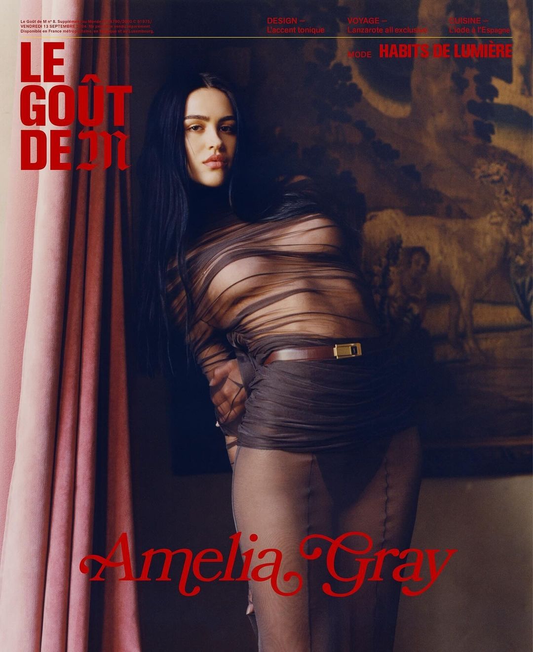 Magazine cover featuring a woman in sheer clothing, set against a backdrop of vintage decor with painted textures and red text overlay.