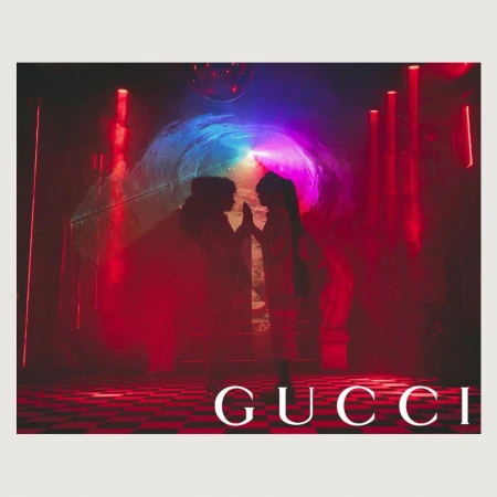 Two people silhouetted against colorful light display with disco ball and Gucci logo on a checkered floor, red and blue tones.
