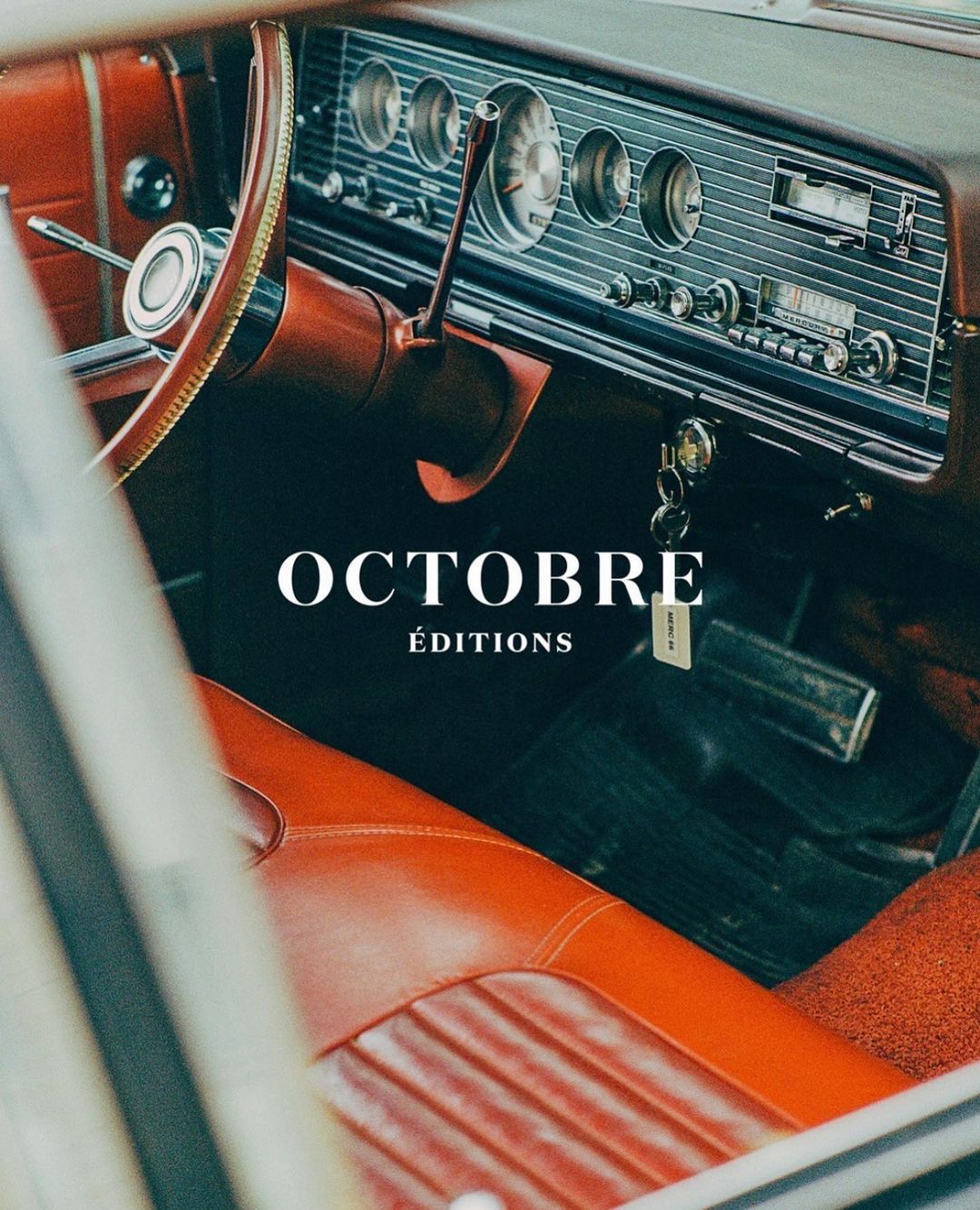 Vintage car interior featuring an orange leather seat, dashboard with gauges, and steering wheel, bathed in soft, natural light.