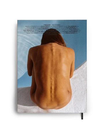Rear view of a person sitting by a blue swimming pool edge, captured by photographer Theo Gosselin.
