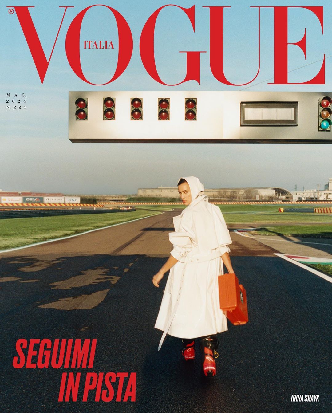 Vogue Italia cover featuring Irina Shayk in a white coat on a racetrack, under the Vogue Italia masthead, with runway lights.