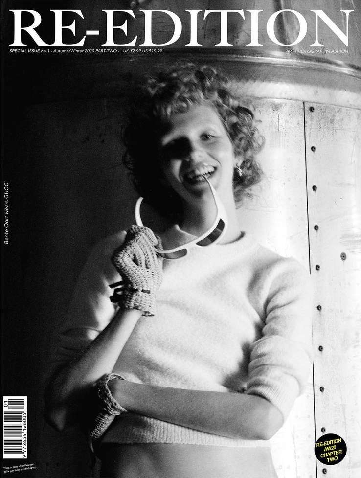 Black and white magazine cover featuring a woman with curly hair wearing sunglasses and knit arm warmers, against a textured metal background.