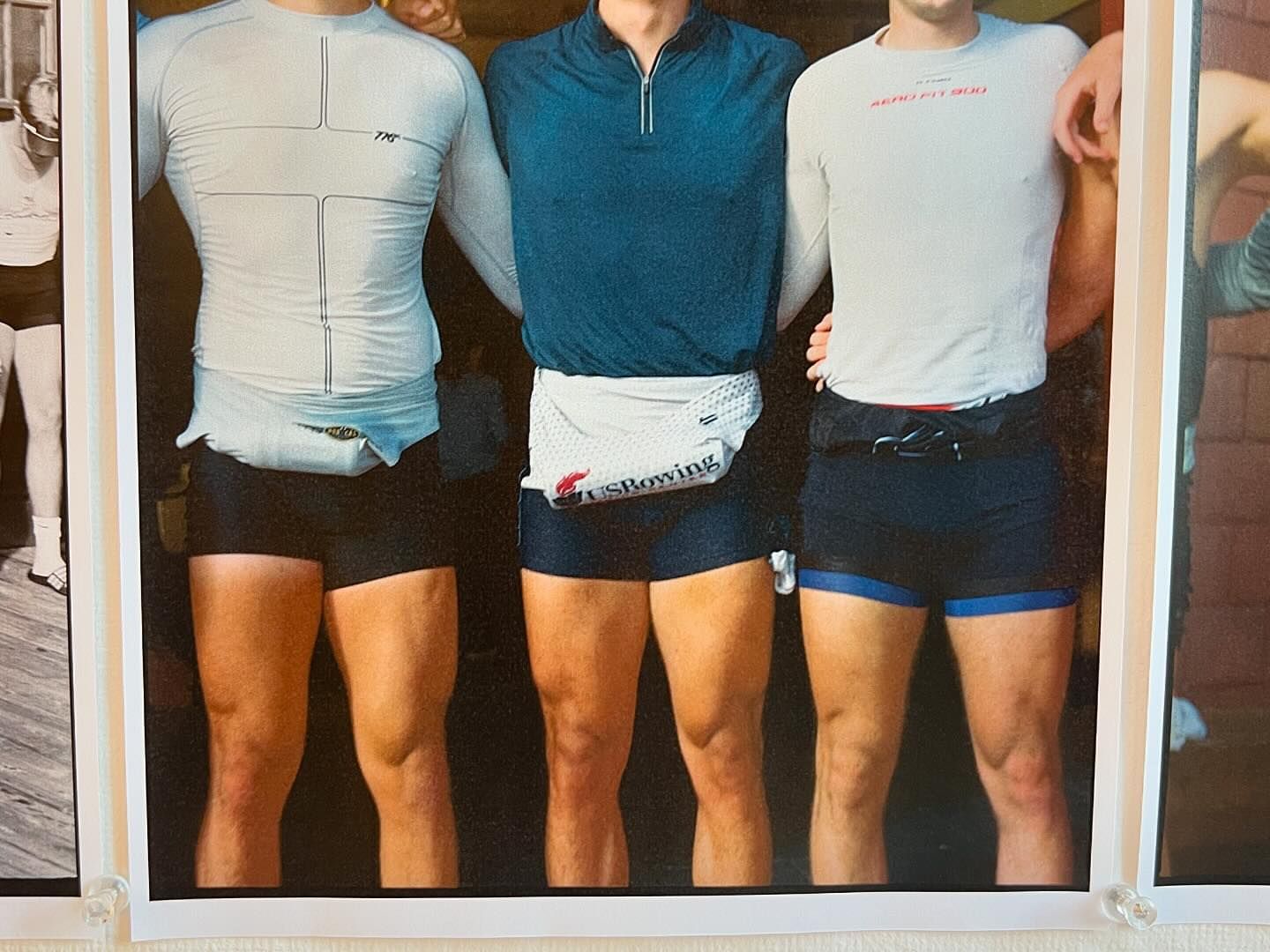 Trio of athletes in athletic wear. The three men are posing in athletic clothes with one wearing a US Rowing fanny pack.