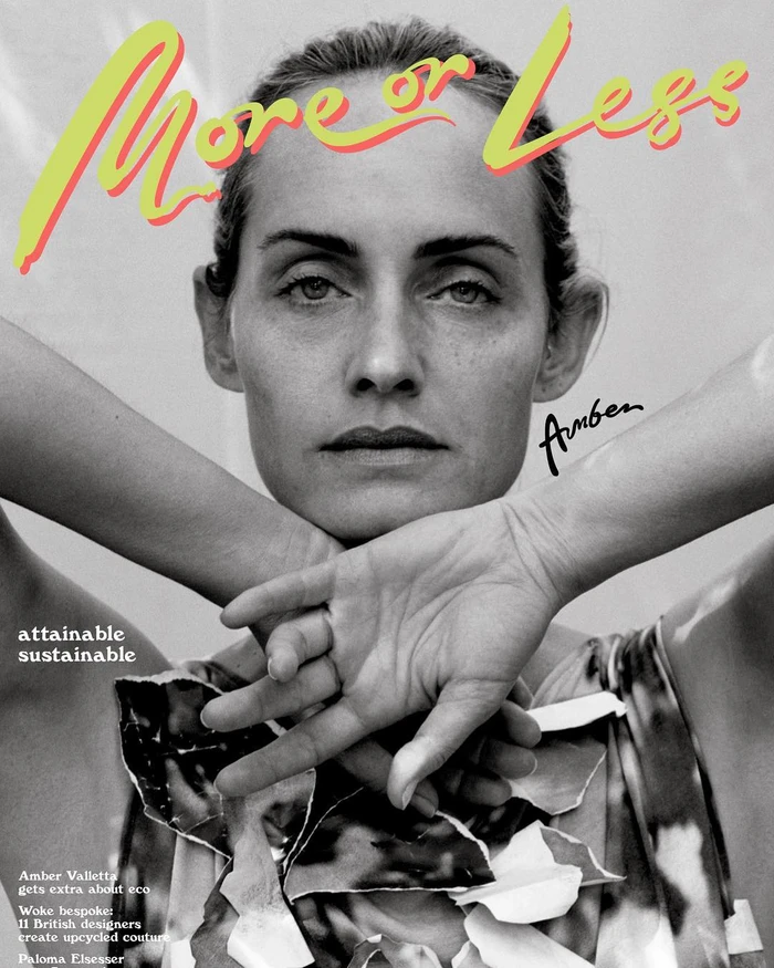 Monochrome portrait of Amber Valletta with hands crossed under chin, featuring bold yellow and red text overlay