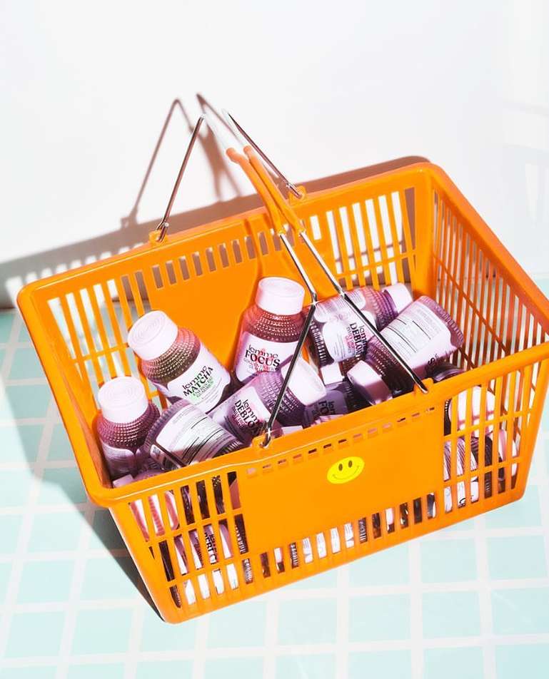 A basket overflowing with bottles of beverage. The shot emphasizes product presentation against a tiled surface.
