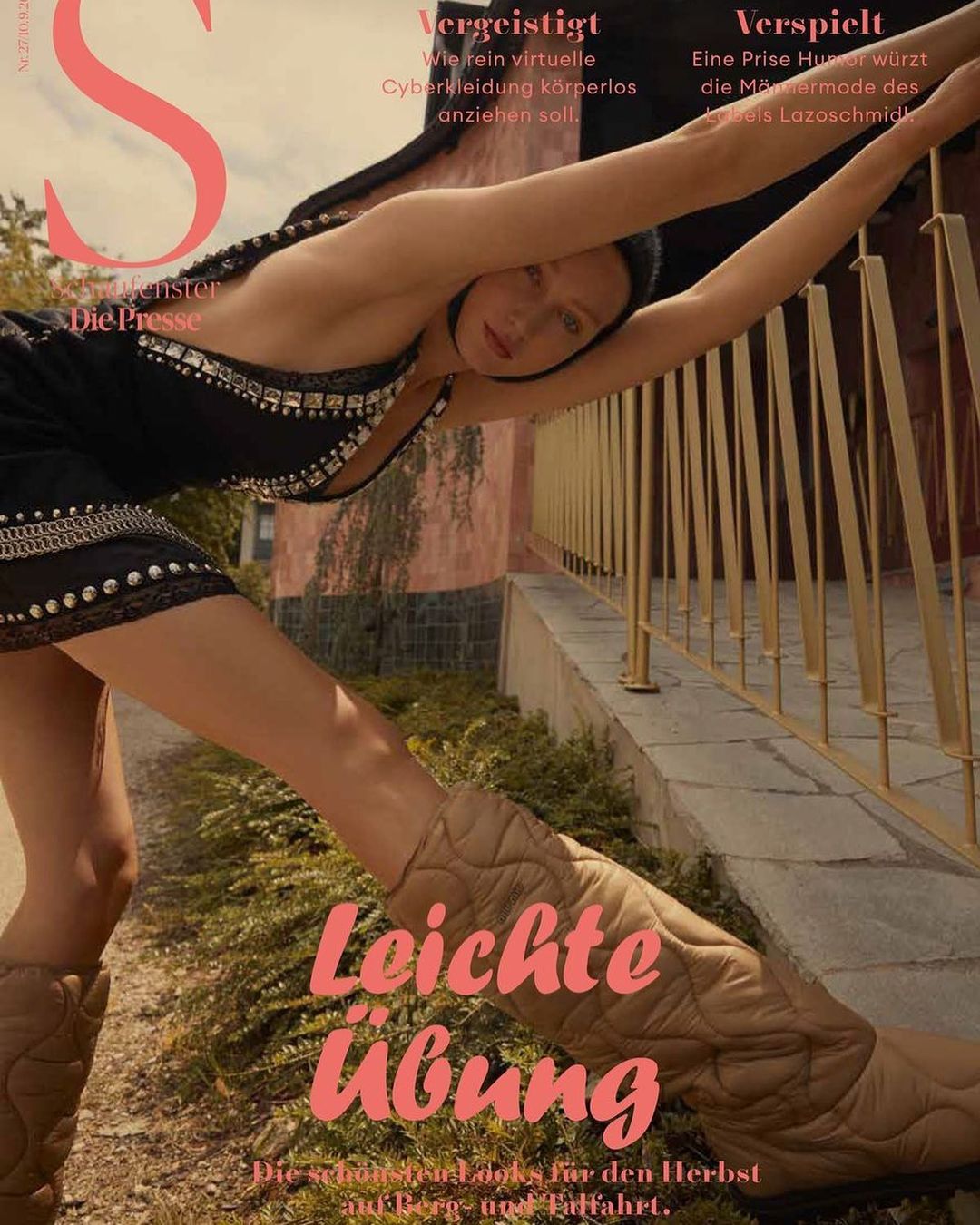 Fashion magazine cover featuring a woman in a black dress and quilted boots leaning against a railing in an outdoor setting with greenery.