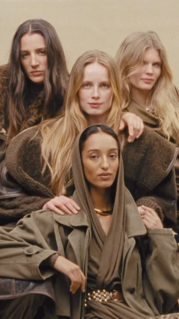 Four women pose in neutral-toned outfits, one wearing a scarf and trench coat, against a soft, diffused background in a vertical fashion shot.