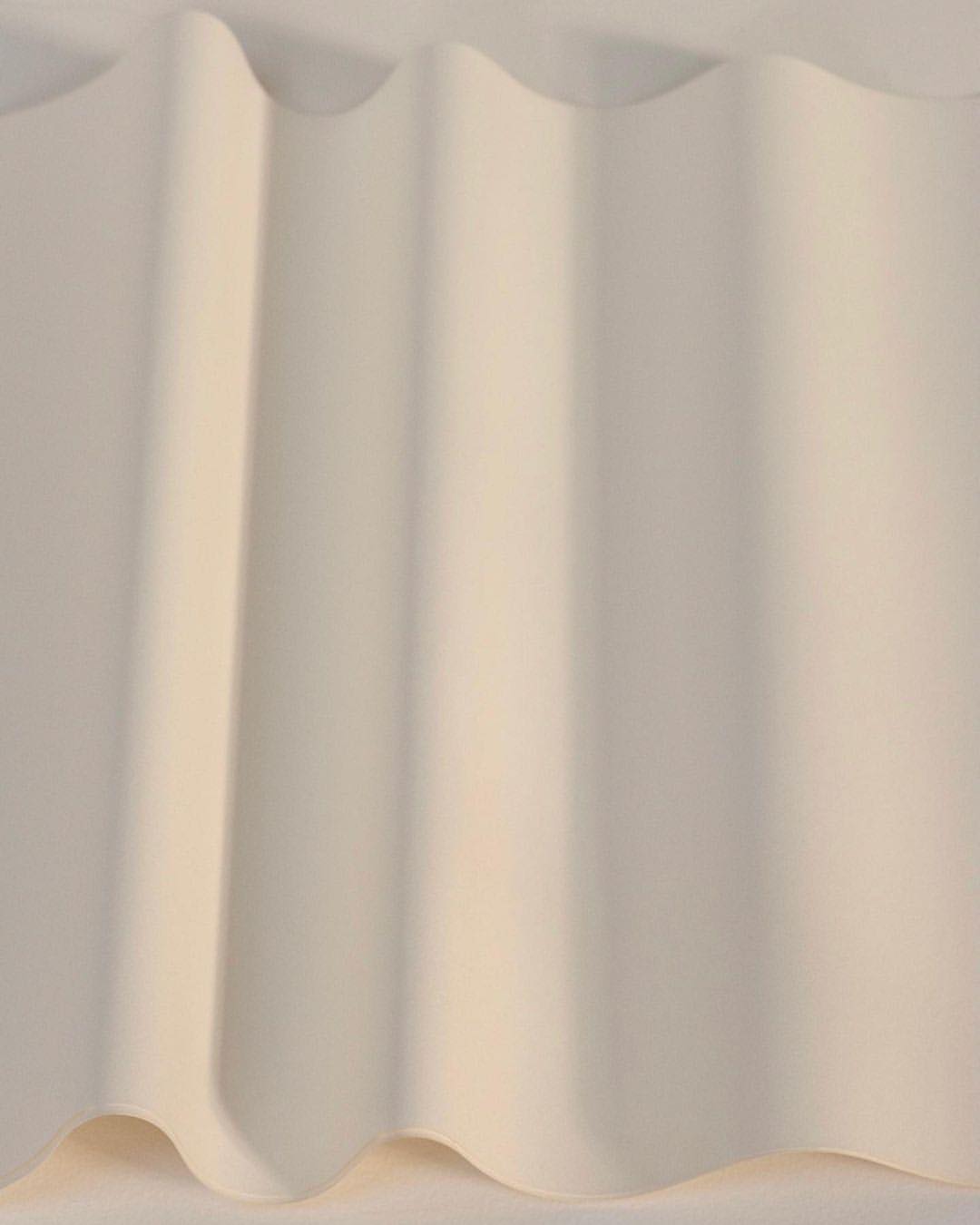Abstract view of a gently folded sheet with soft, diffused lighting creating subtle shadows, highlighting the texture and form.