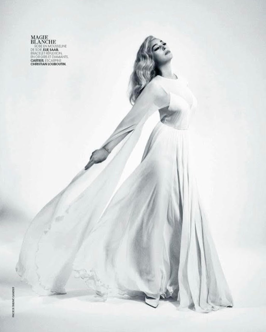 Model in long white silk chiffon dress with flowing sleeves against a white background by photographer Thiemo Sander.