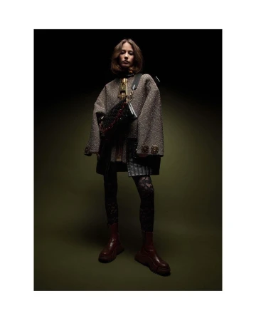 Model wearing a textured tweed jacket, lace leggings, and red boots, photographed by Thierry Le Gouès in Milan.