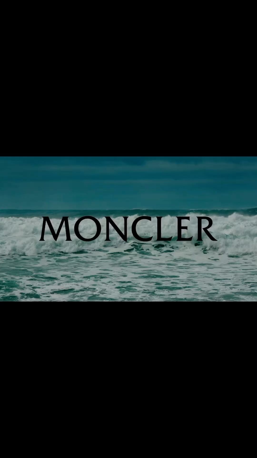 Waves crash in the ocean with 'MONCLER' text overlay, capturing a cinematic scene with a nature and fashion crossover.