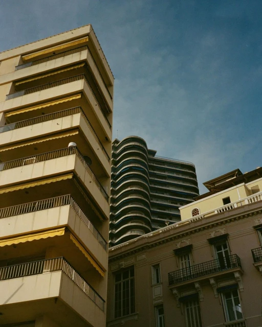 Exterior shot of urban buildings in daylight with architectural elements. Balconies and various apartment structures visible against sky.