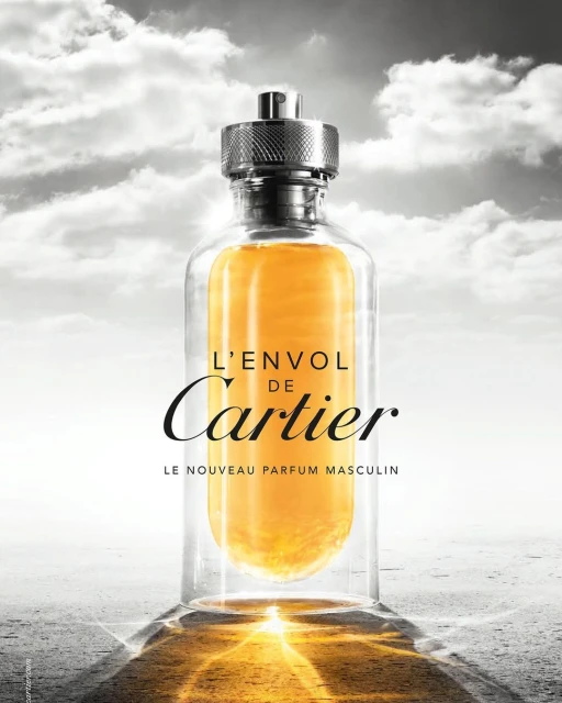 Cartier L'Envol de Cartier parfum bottle against a background of cloudy sky and stone texture, presented as an advertising shot.