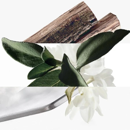 Close-up studio shot with white flowers, green leaves, a silver ribbon, and textured wood pieces against a white backdrop.