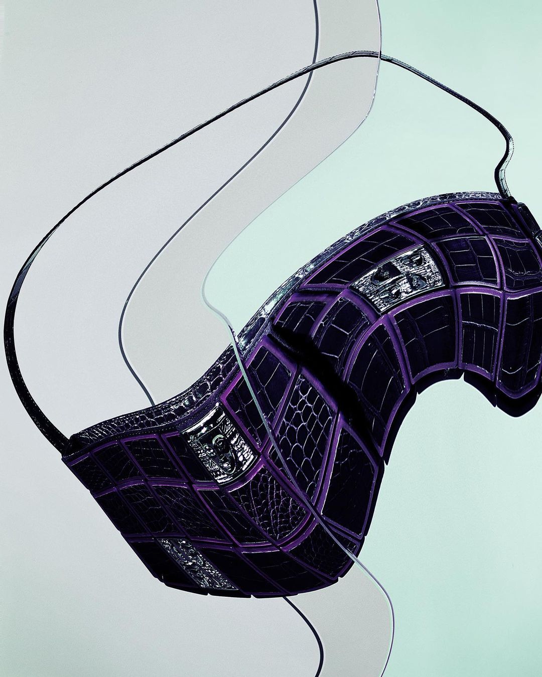 Abstract product shot: A purple purse with grid pattern floats amidst translucent plastic waves on a pale green backdrop.