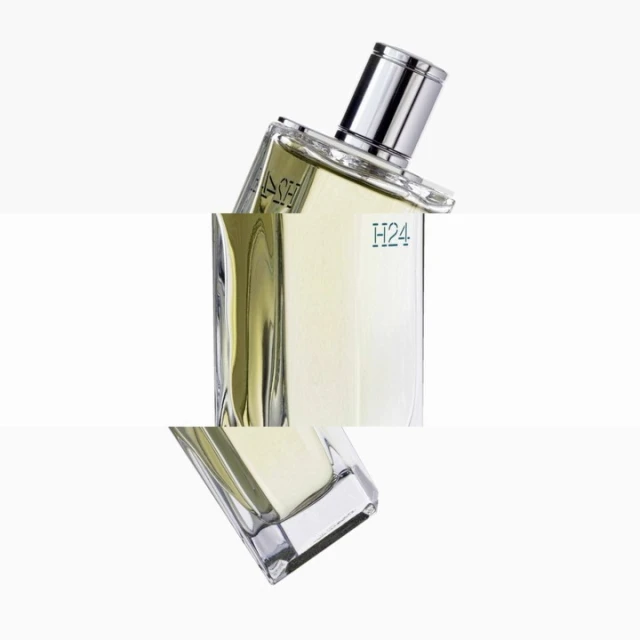 Angled studio shot of a transparent glass perfume bottle with a silver cap against a white background, showcasing minimalist product design.