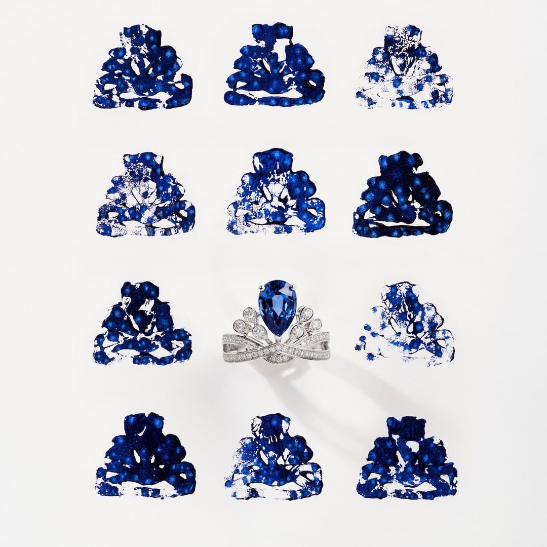 Abstract jewelry product shot of a silver ring featuring a blue sapphire, contrasted with blue and white abstract design stamps.