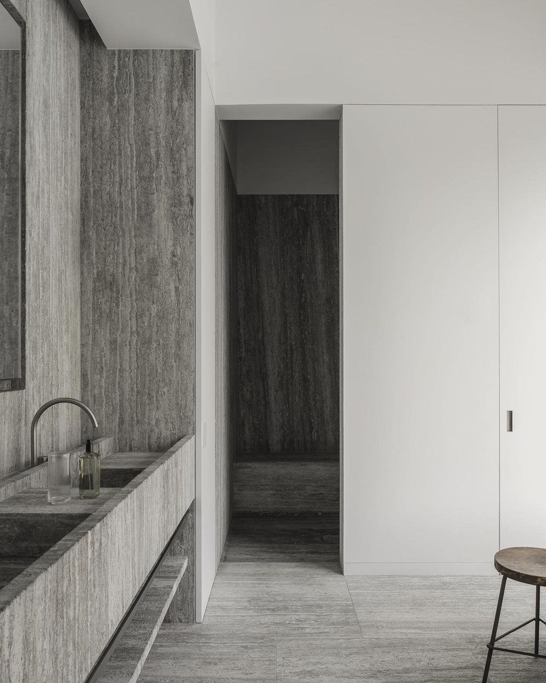 Modern bathroom interior featuring a marble sink, minimalist decor, and a neutral color palette, showcasing contemporary design elements.