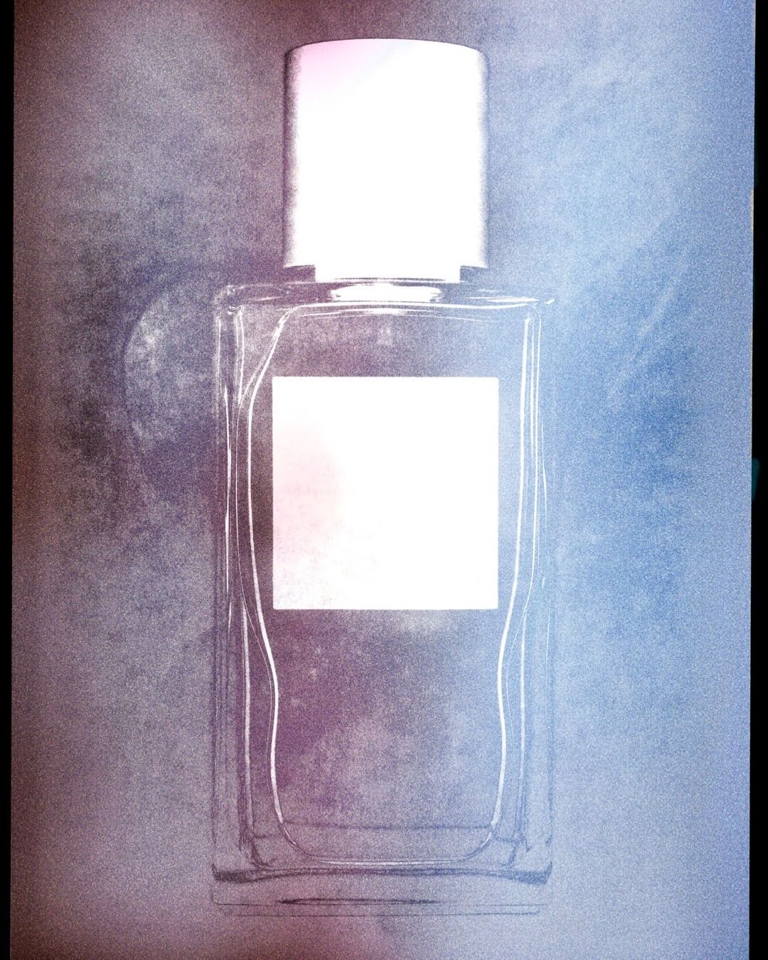 Close-up product photograph of a clear rectangular perfume bottle with a silver cap against a textured background by Thomas Deschamps
