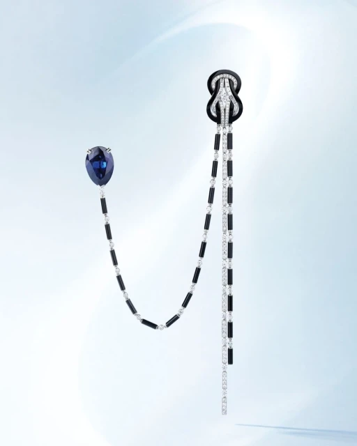 Elegant jewellery featuring blue and black gemstones with diamond accents, displayed on a soft gradient background. Sophisticated design.
