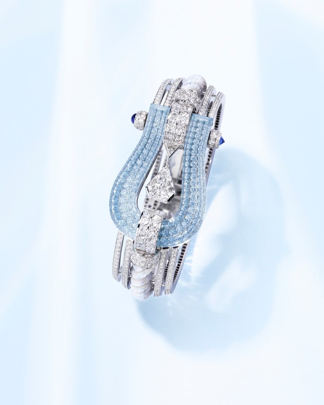 Elegant diamond bracelet with blue gemstones set on a gradient blue backdrop for jewelry advertising, high-end fashion accessory.