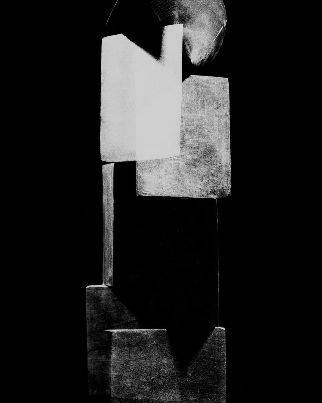Abstract art piece with geometric shapes in grayscale against a stark black background. Features a mix of squares, rectangles, and a circle.