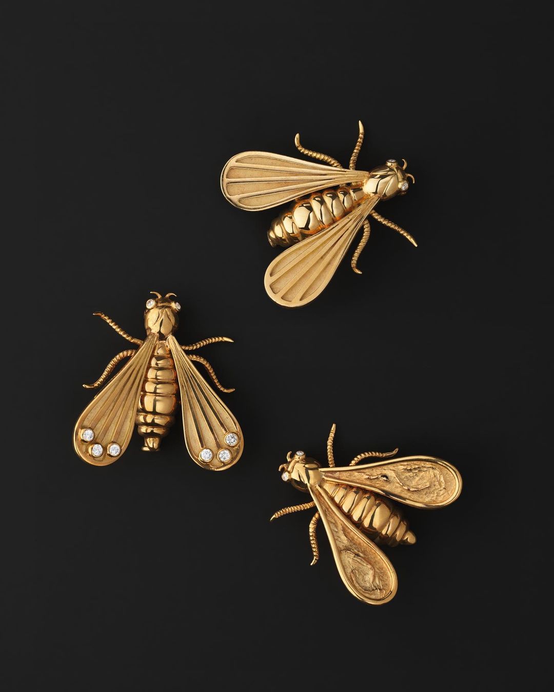 Three gold insect brooches featuring a bee design on a black background, showcasing detailed craftsmanship and jewelry design.