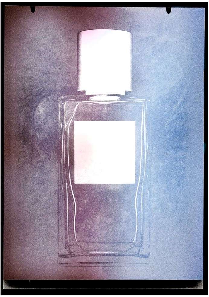 Elegant close-up of a clear glass perfume bottle with a white cap against a soft, textured background in shades of blue and pink.