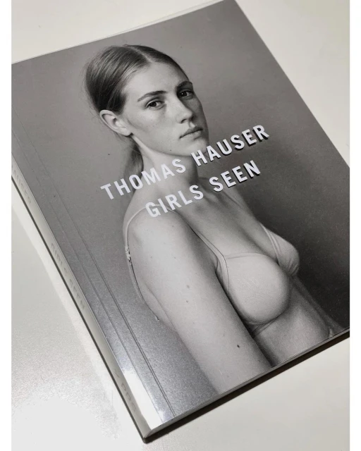 Book cover featuring a portrait of a woman with light skin wearing a bra top against a gray background, with the title 'Thomas Hauser'.