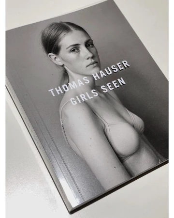 Book cover featuring a portrait of a woman with light skin wearing a bra top against a gray background, with the title 'Thomas Hauser'.