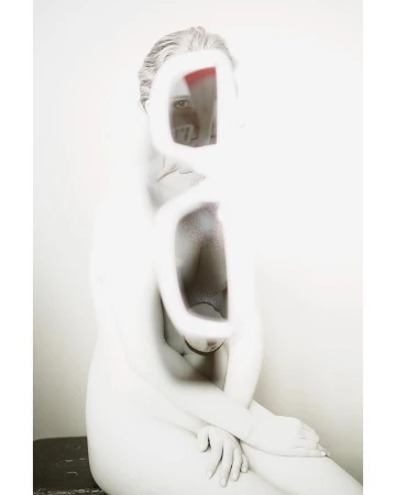 Abstract nude art photography featuring a woman with an obscured face in a blurred, desaturated style against a plain background.