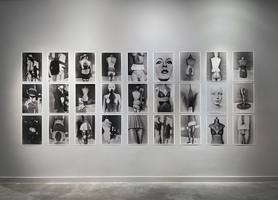 Monochrome gallery wall featuring photographs of torsos and mannequin parts, arranged in rows and columns, creating a minimalist aesthetic.