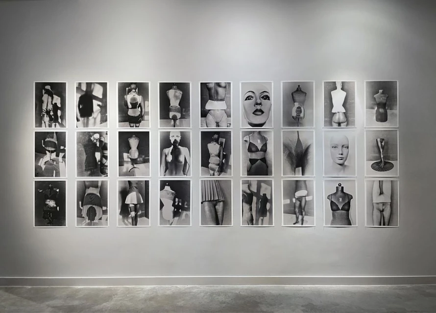 Monochrome gallery wall featuring photographs of torsos and mannequin parts, arranged in rows and columns, creating a minimalist aesthetic.
