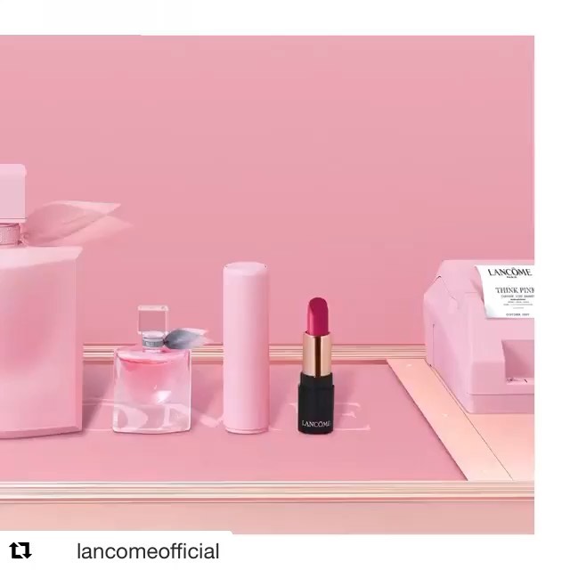Still life arrangement featuring Lancôme perfume, lipstick, and beauty products in a light pink setting, highlighting beauty and cosmetics.