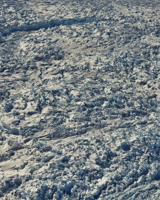 Scenic overhead view of a vast, rugged glacier with deep crevices and icy formations, showing the raw beauty and scale of nature.