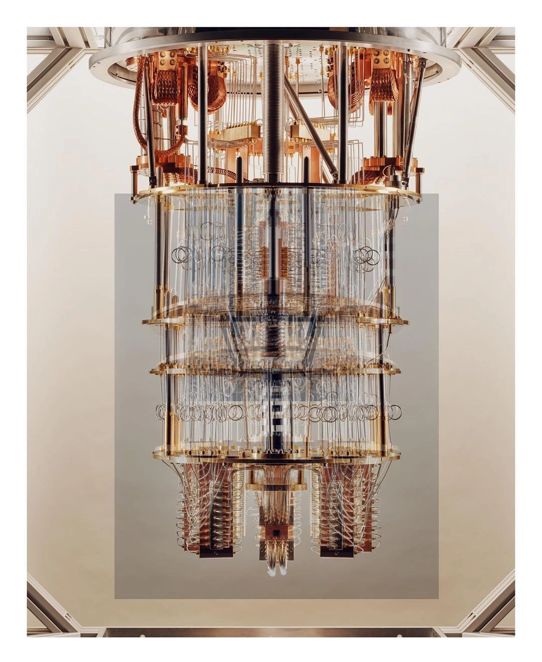 A close-up vertical photograph of a complex cryogenic quantum computer dilution refrigerator by Thomas Prior.