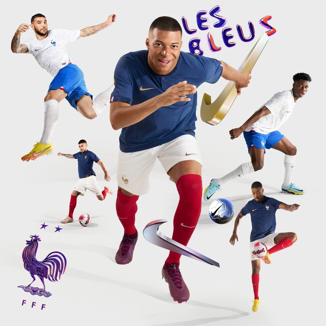 Group of male soccer players in mid-action wearing blue and white uniforms with red socks and Nike shoes set against a white backdrop.