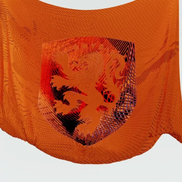 Orange patterned fabric with a shield emblem featuring a lion, showcasing textures and abstract design elements against a light backdrop.