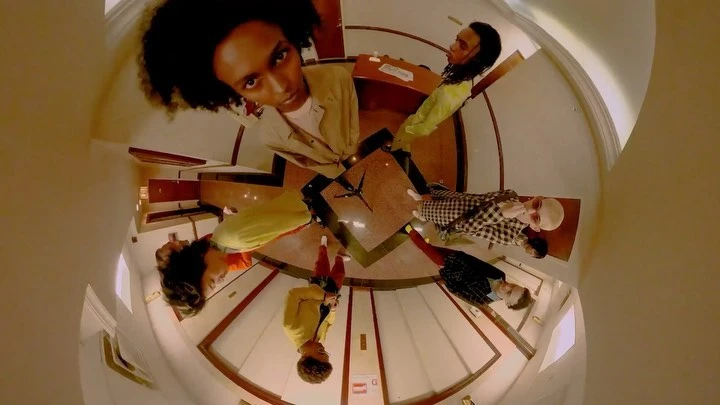 A unique fisheye perspective showing a diverse group of young adults in a stylish indoor setting, showcasing modern fashion and an urban lifestyle.