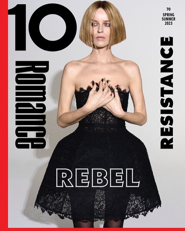 Magazine cover featuring a woman in a black dress with hands clasped against her chest, alongside typography and a red border.