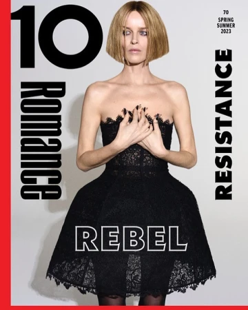Magazine cover featuring a woman in a black dress with hands clasped against her chest, alongside typography and a red border.