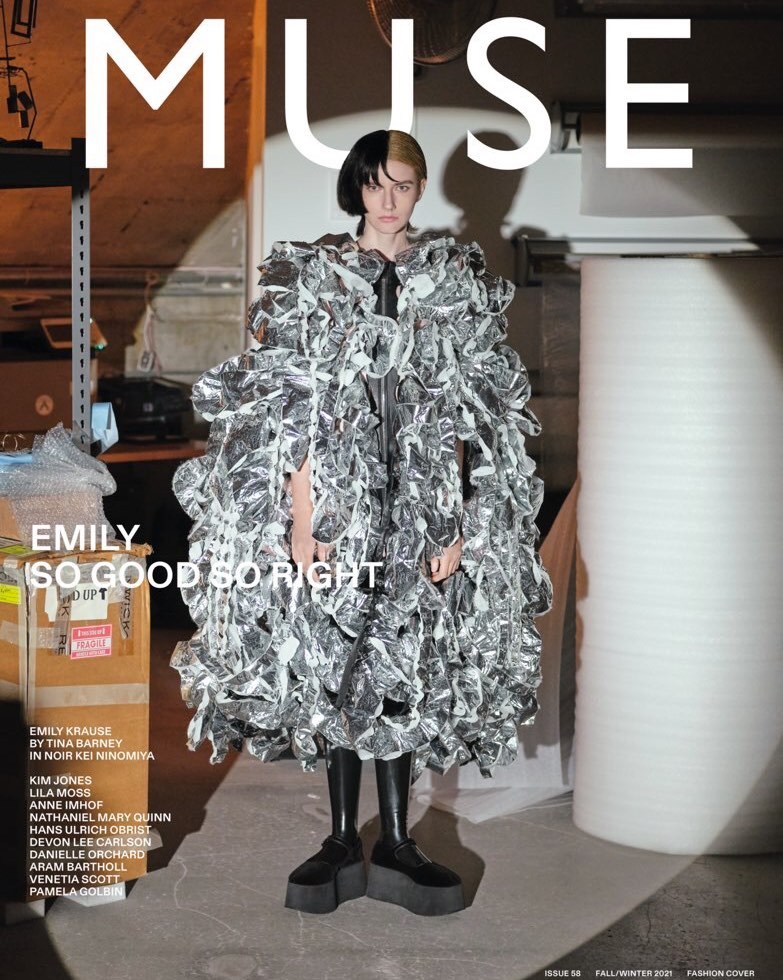 Fashion magazine cover featuring a female model wearing a silver ruffled coat and black platform shoes in a studio setting.