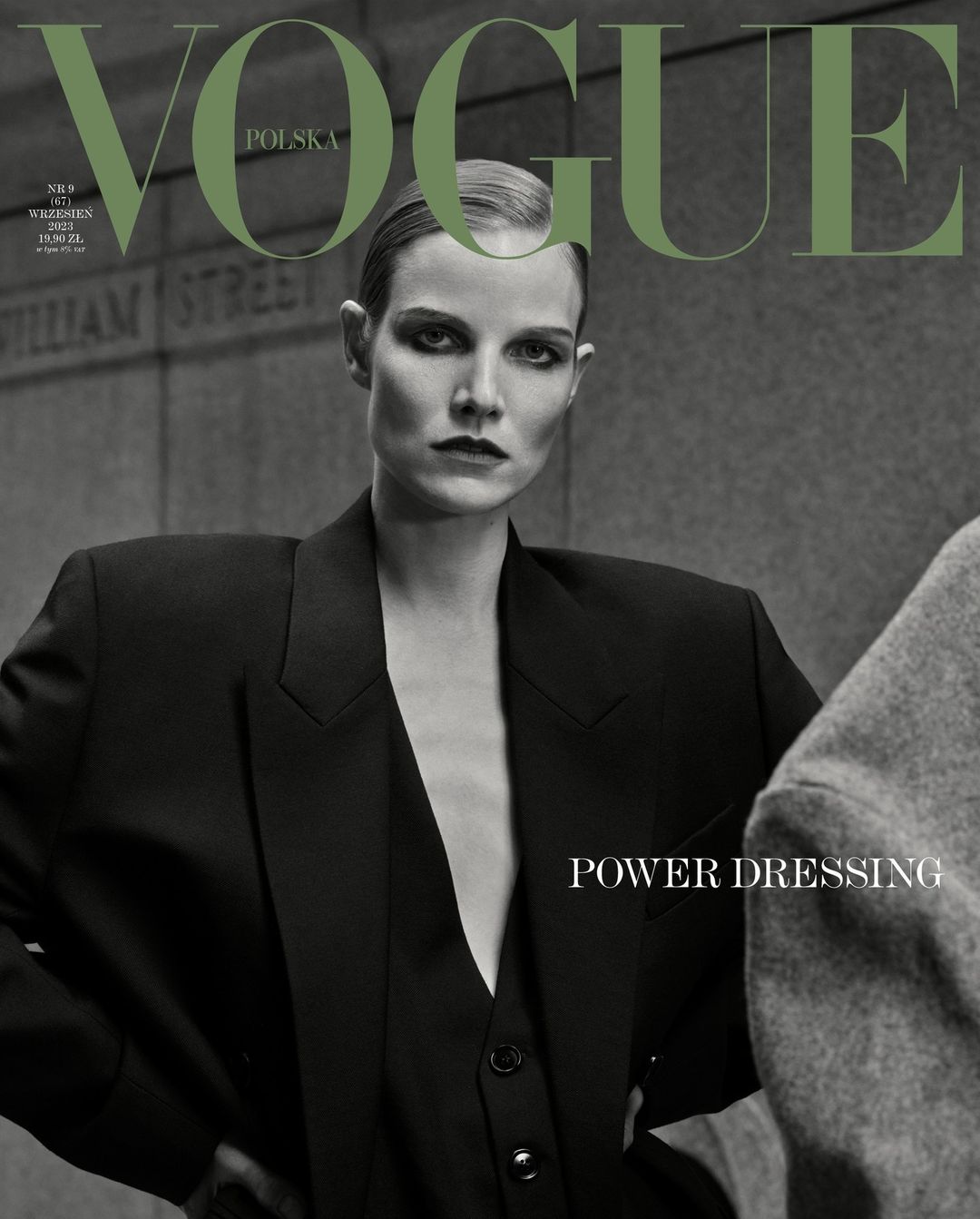 Vogue Polska cover featuring a model in a black blazer and vest against a muted wall backdrop. "Power Dressing" is featured text.