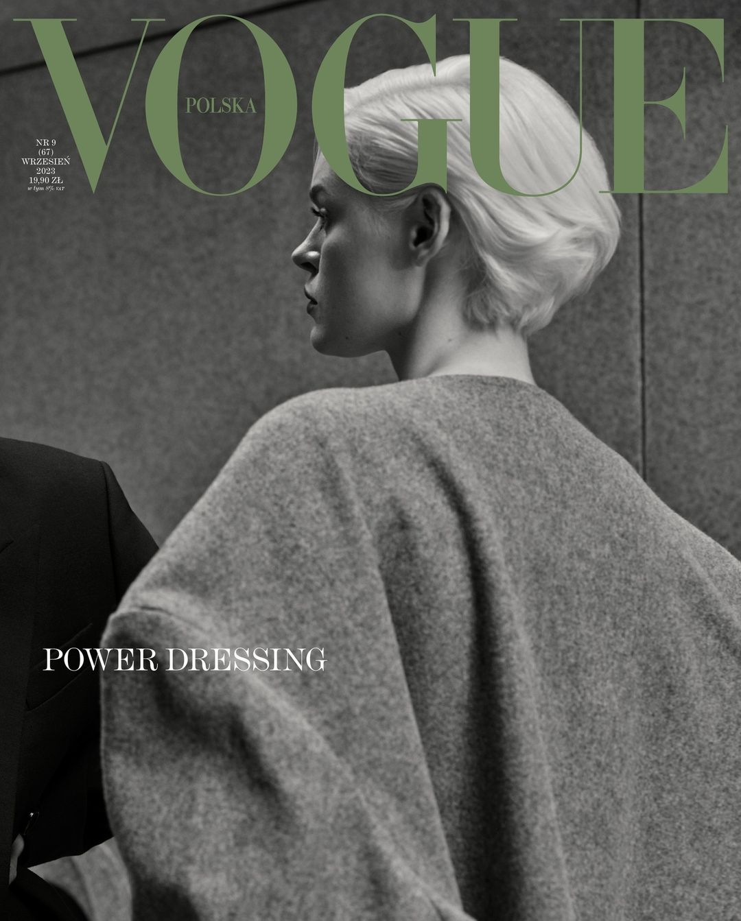 Fashion editorial cover of Vogue Polska with a woman in a gray wool coat, cropped haircut, and the Vogue logo in olive green.